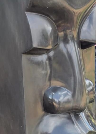 Nose and lips, polished, emerging from the flat column