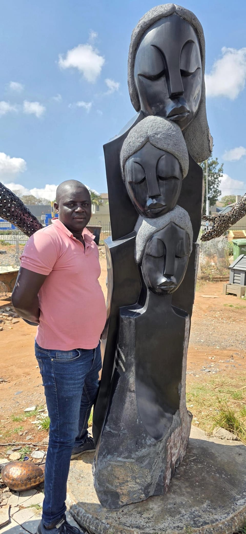 Langton beside his three-face sculpture, which stands taller than him