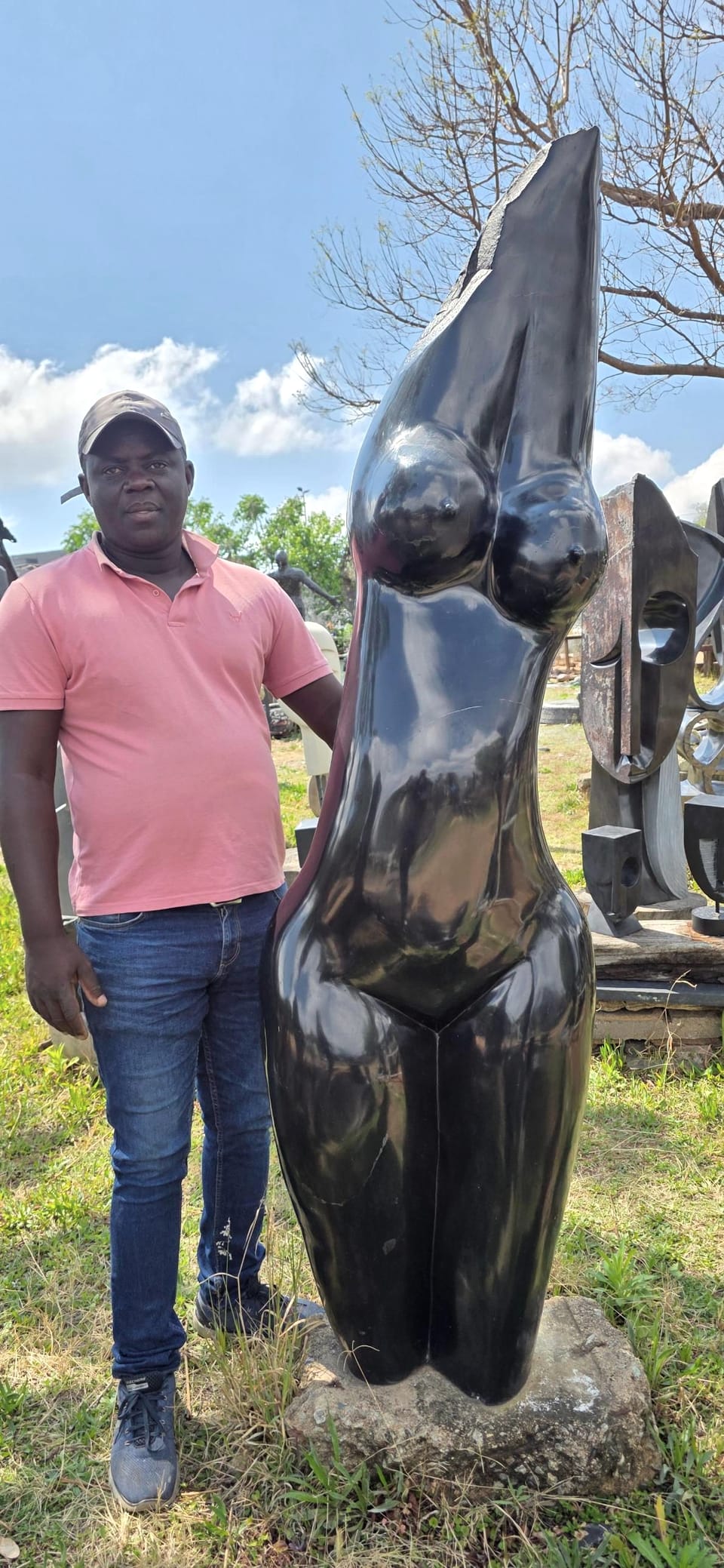 Polished dark stone female torso, taller than Langton, standing beside it