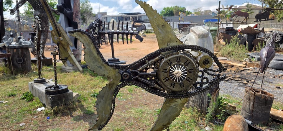 Long welded metal fish on a stand with a circular sun-wheel at its centre
