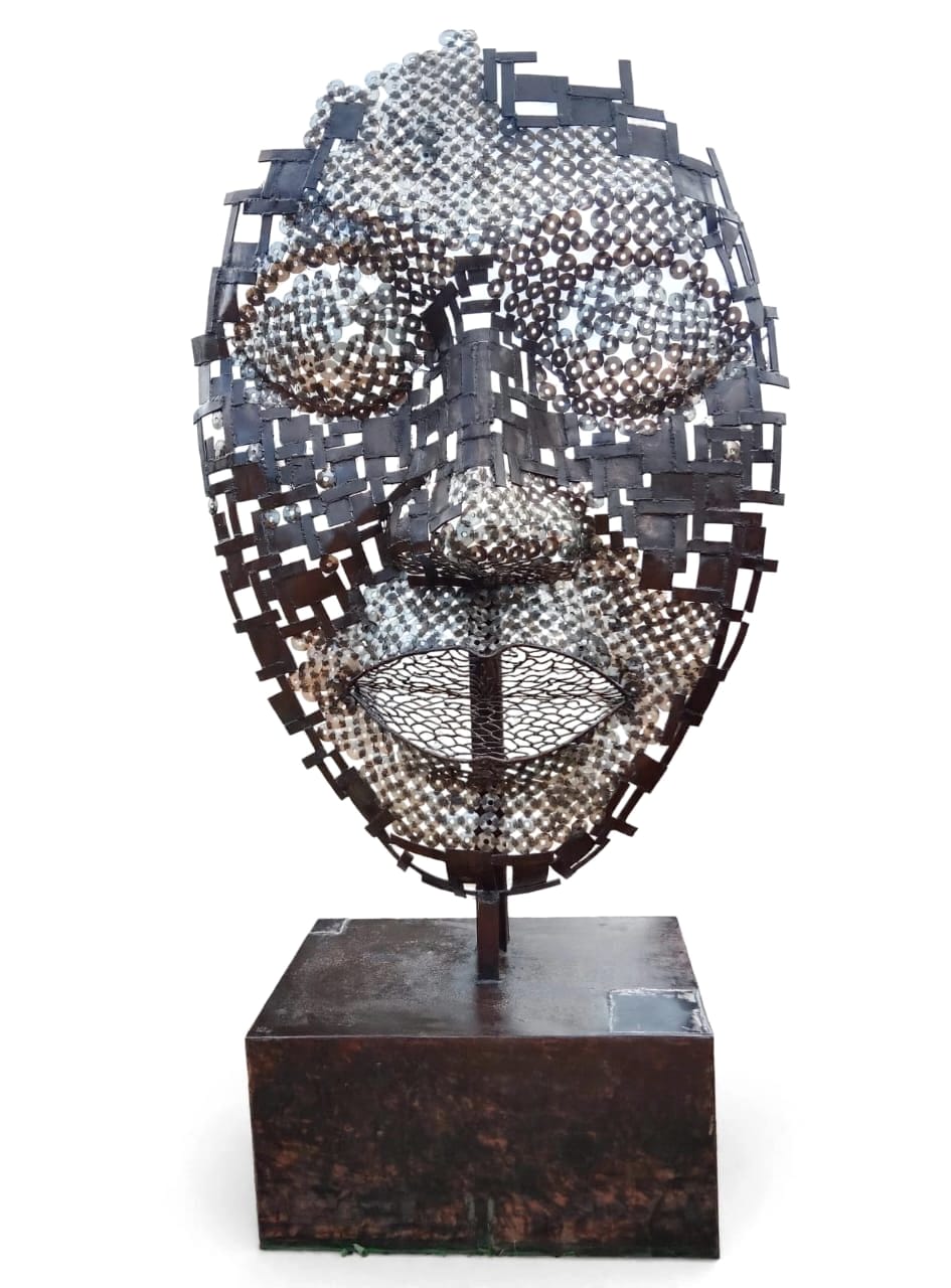 Face in steel frame and washers on a dark base, on white