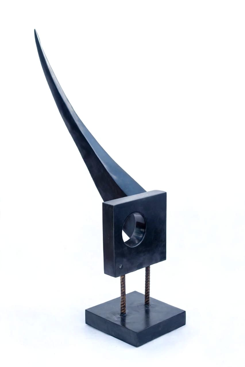Tall curved black horn rising from a square frame with a round opening, on two rebar legs and a black base, on white