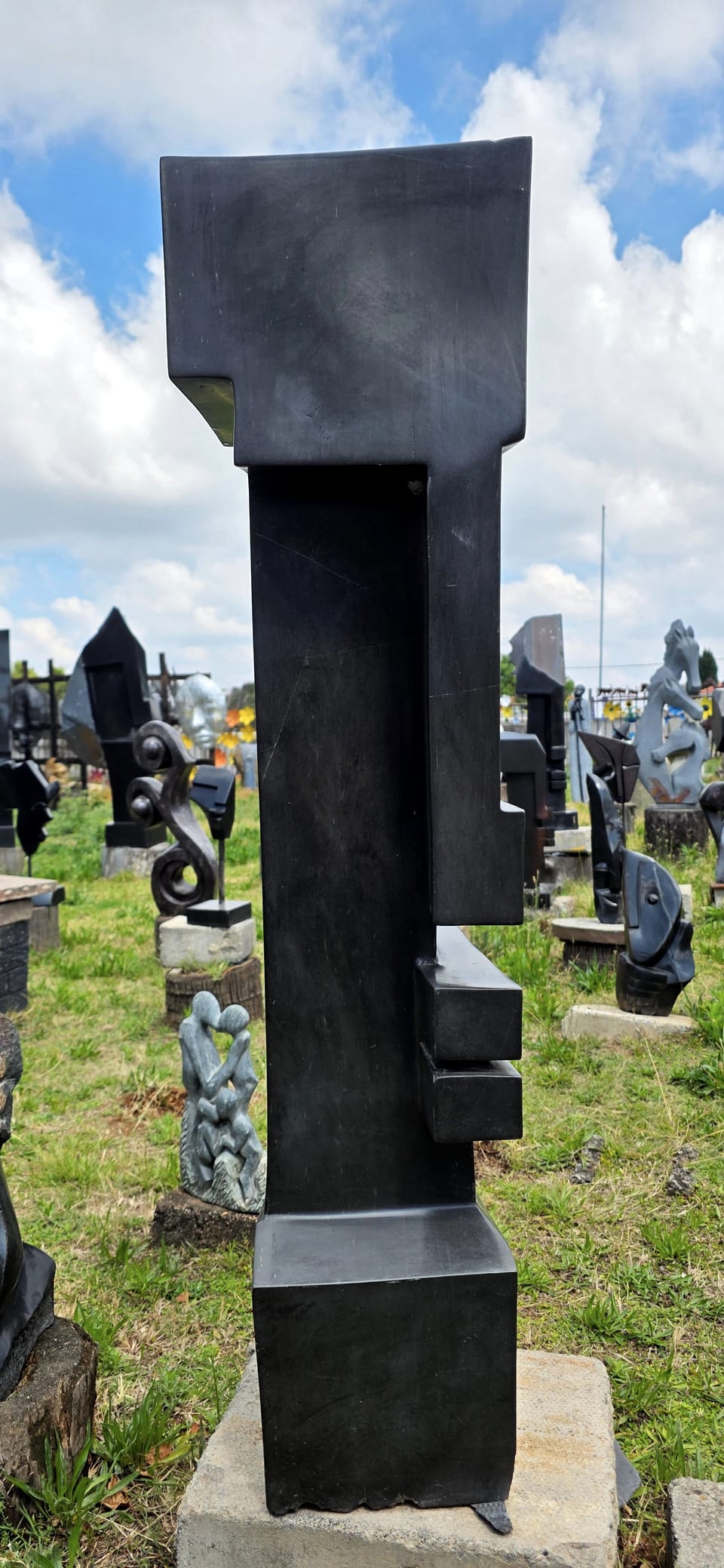 Tall dark stone tower with a recessed step cut into one side, on a square base