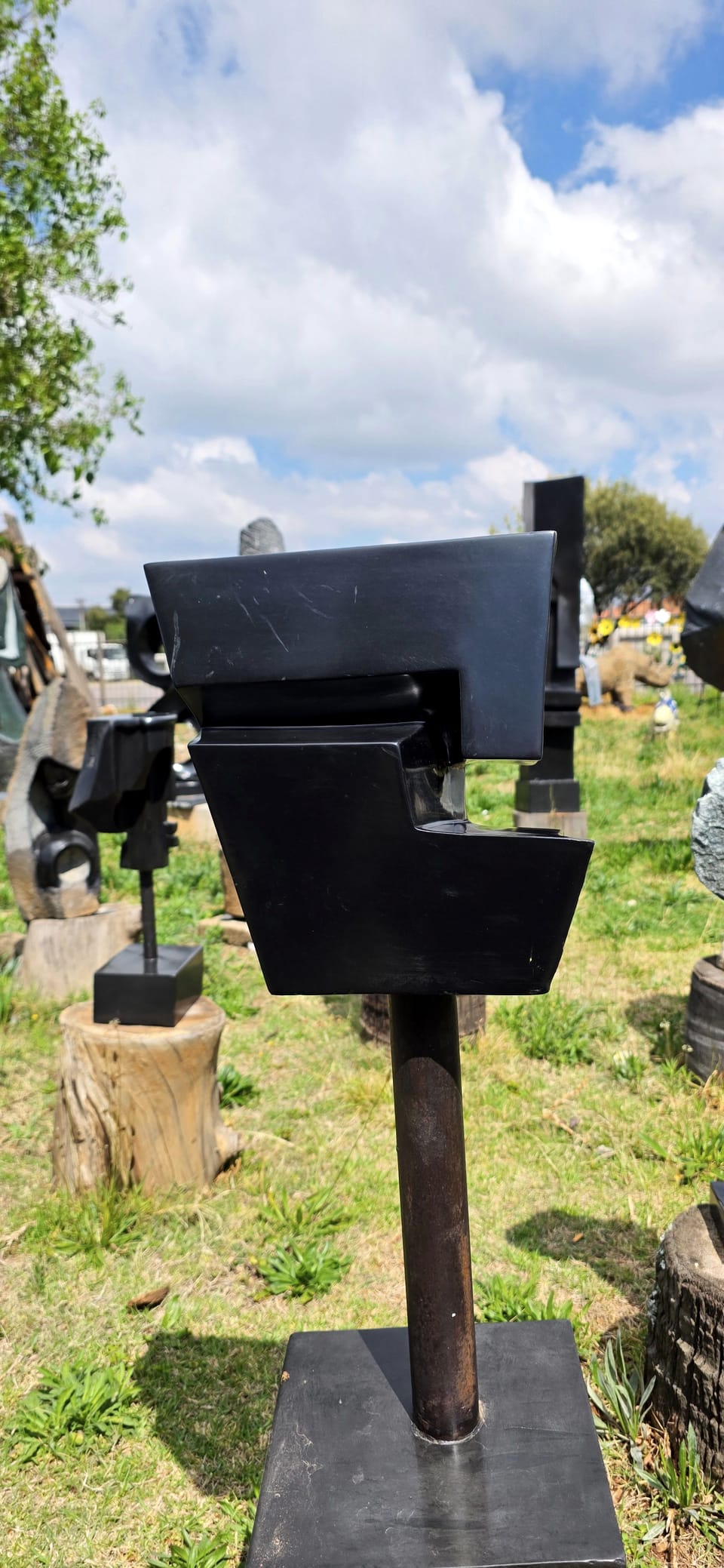 An angular stone head projecting forward from a vertical plane, raised on a metal stem
