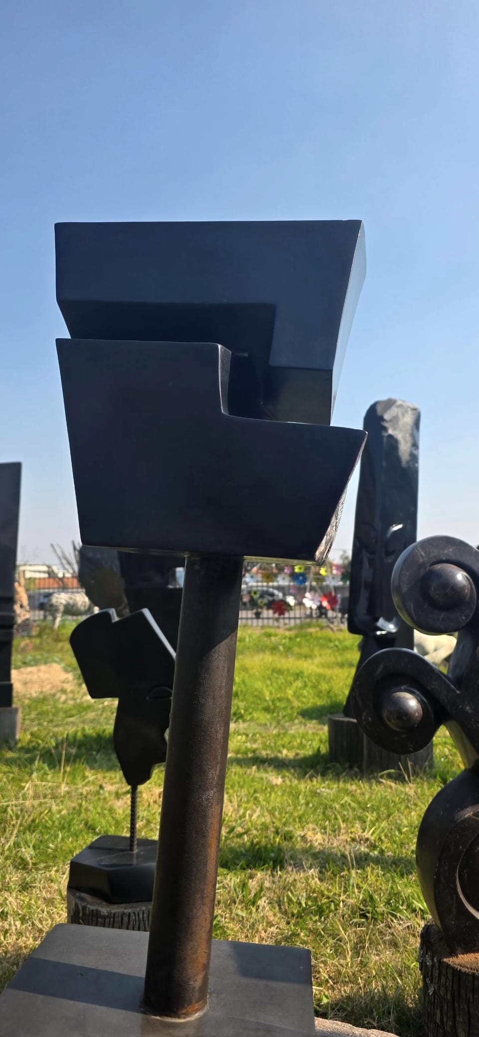 The cantilevered head on its metal stem, seen against a clear sky