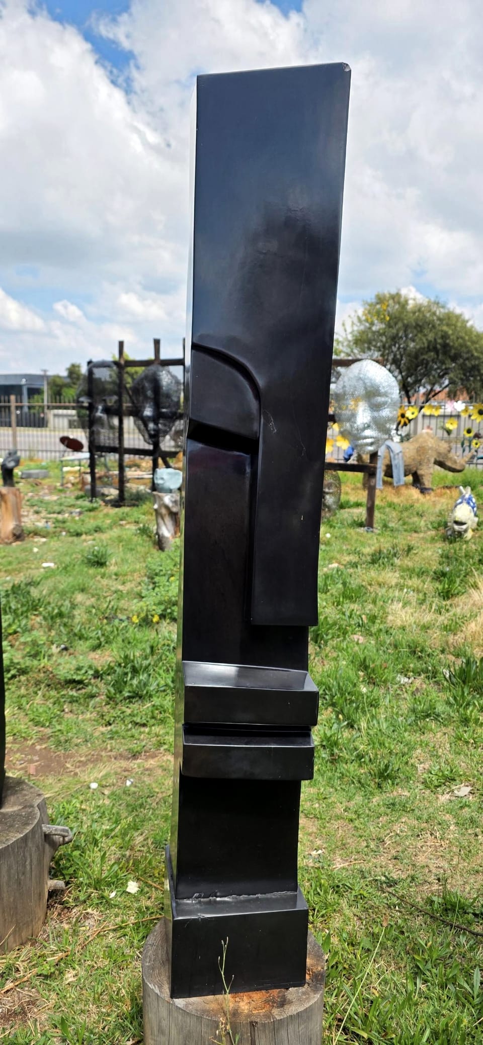 The slender column seen from a second position in the yard