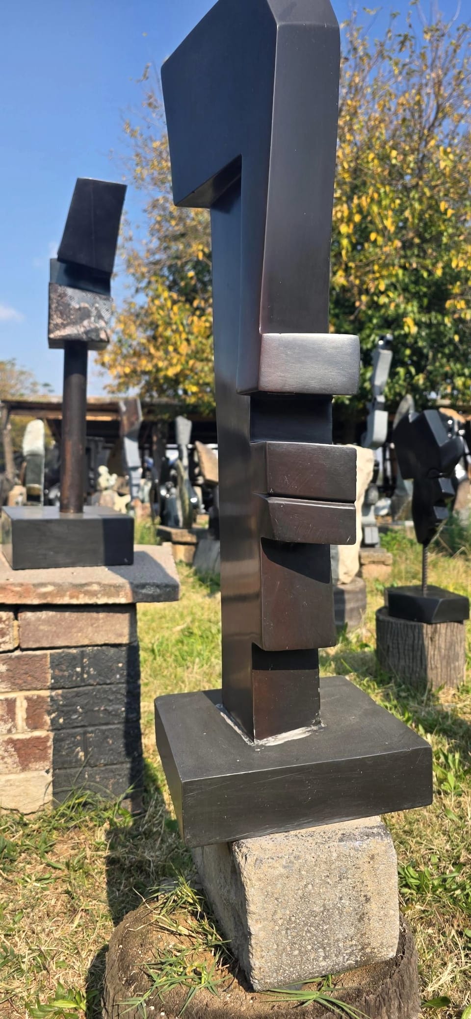 Dark polished stone profile of stepped blocks rising from a square base