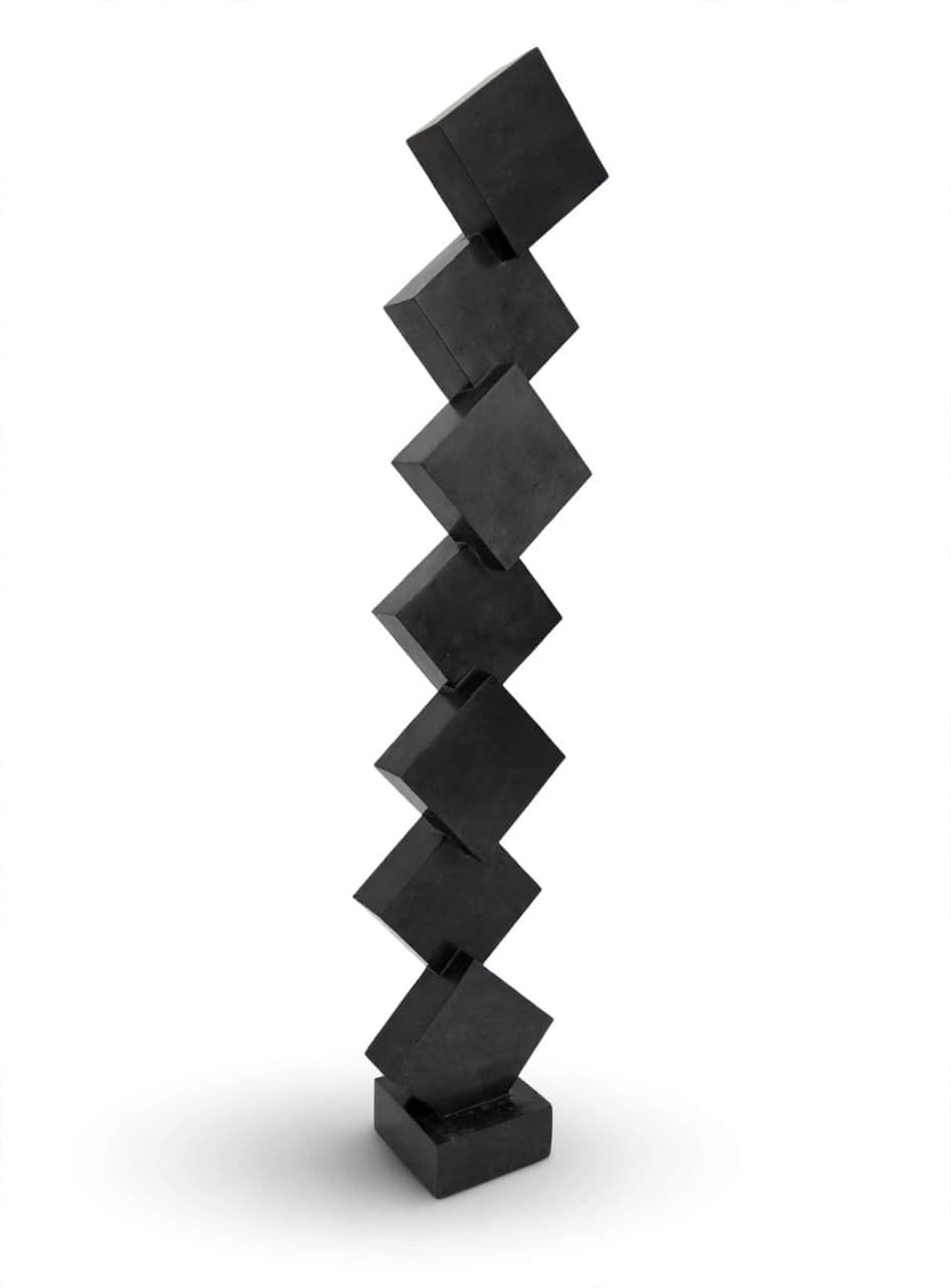 Column of dark polished stone cubes balanced corner to corner, on white