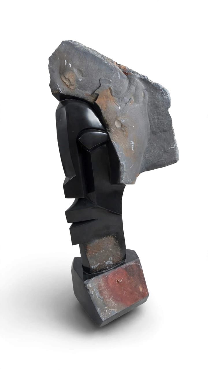 Stepped dark stone face beneath a leaning slab of grey natural rind, on white