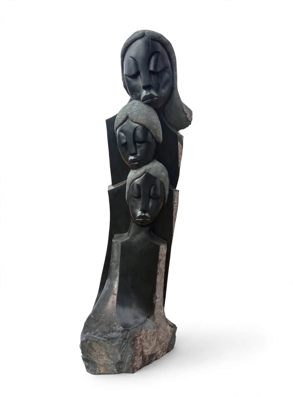 Three faces stacked one above another in polished dark stone with textured hair, on white
