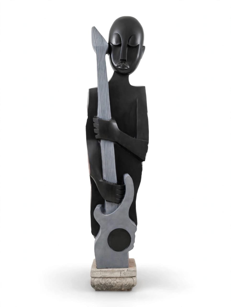 Standing stone figure with a polished dark face and body holding a pale grey carved guitar, on white